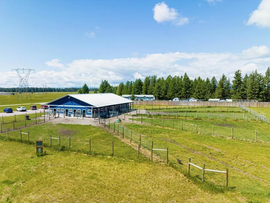 The fenced ranch yards seen from the building, with the Flathead Valley range beyond.