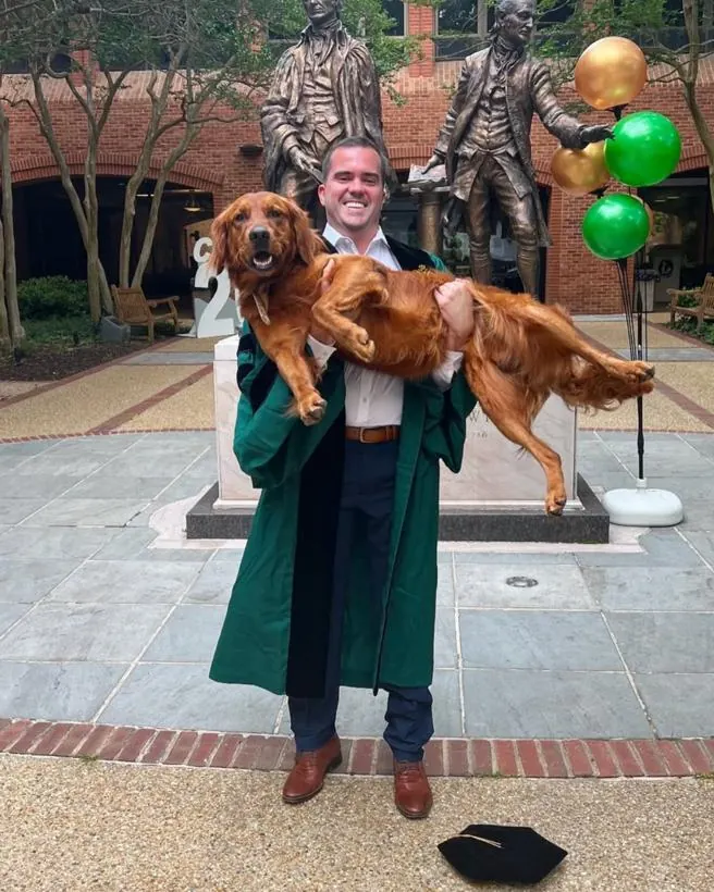 Matthew holding his dog on graduation day at William & Mary.