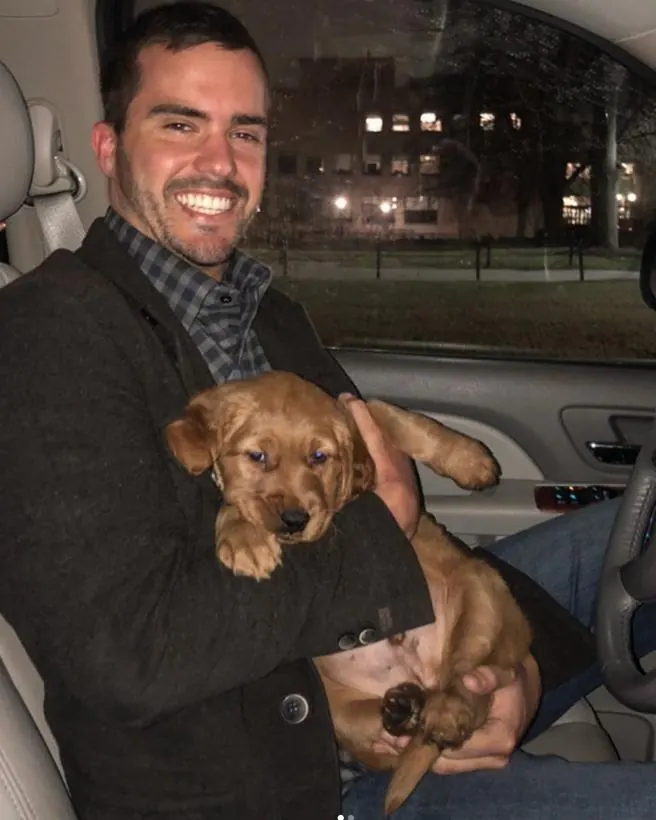 Matthew with his golden retriever as a puppy.
